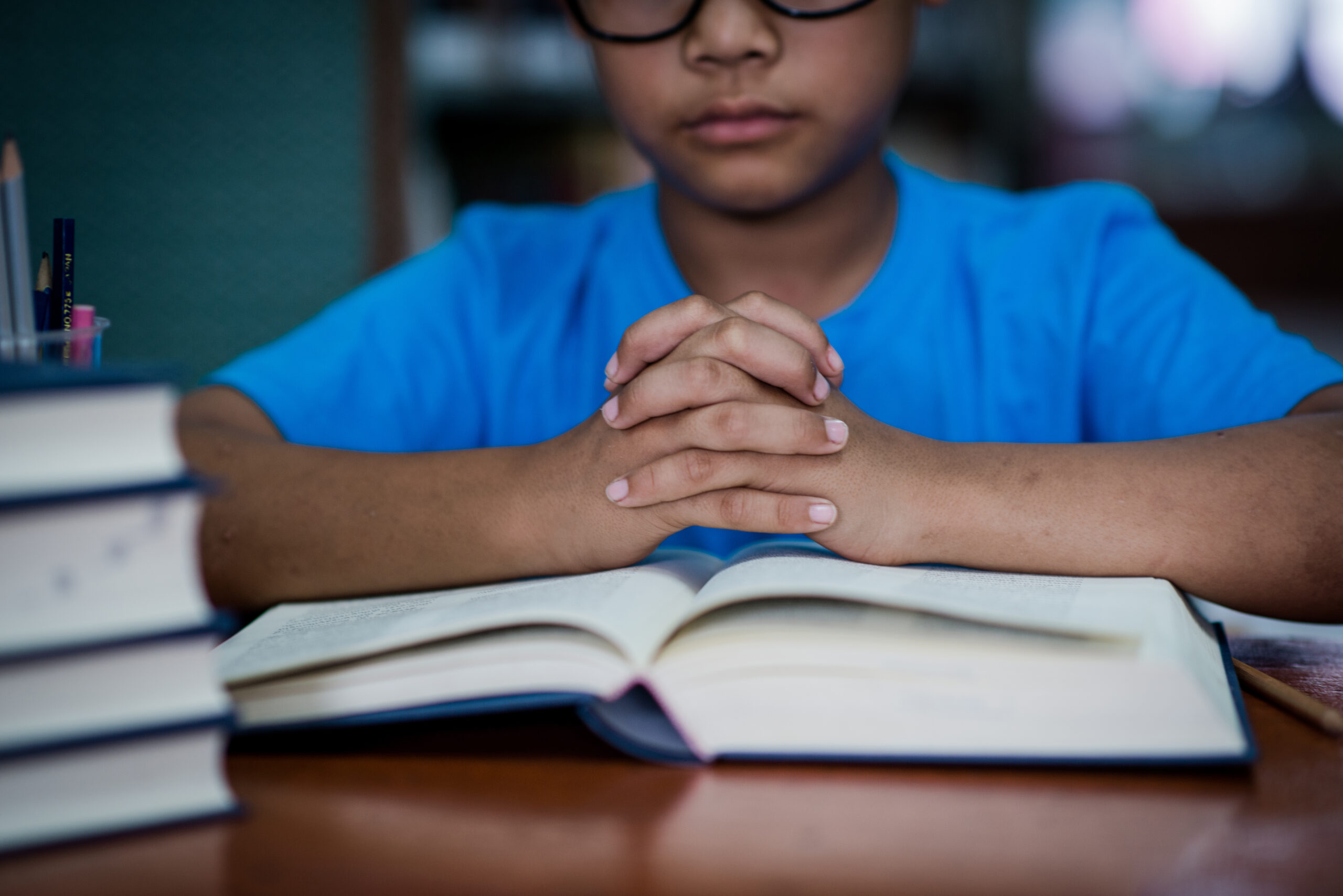 Young student reading a book in a library